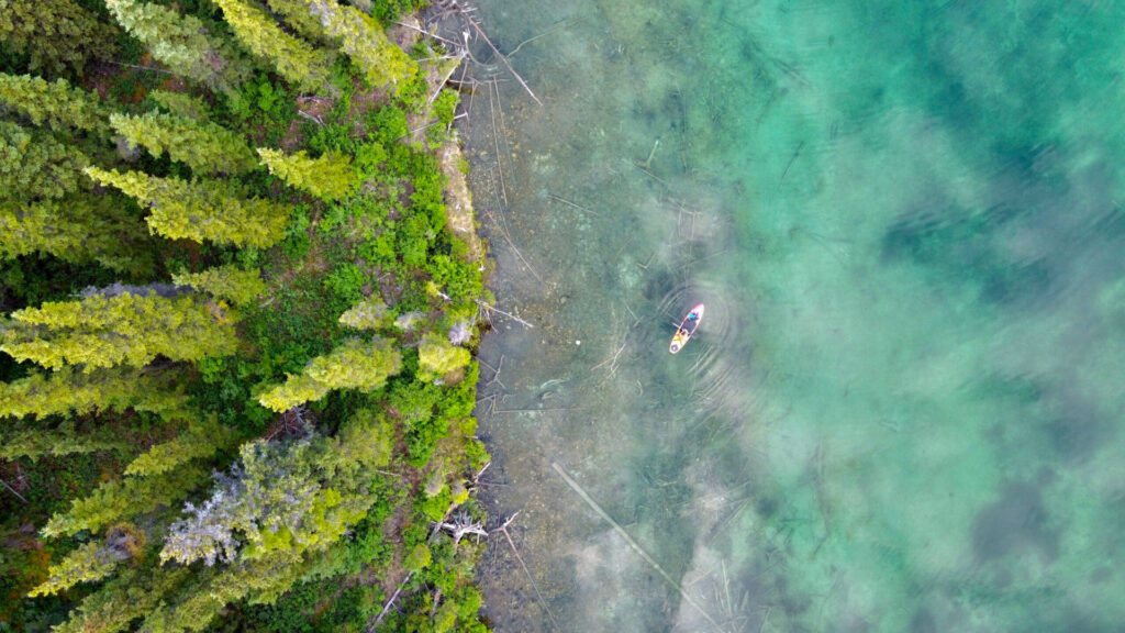 drone view of paddle boarder on lake
